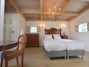 ein Schlafzimmer mit einem Bett, einem Tisch und einem Kronleuchter in der Unterkunft Cozy holiday home in Volkel with Sauna in Volkel