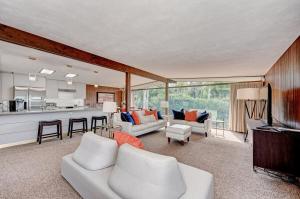 a living room with white furniture and a kitchen at Waterfront Home by Ralph Twitchell in Sarasota