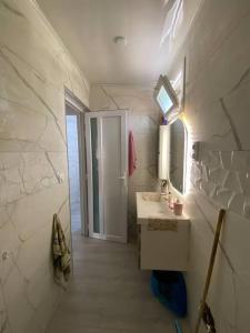 een badkamer met een wastafel en een spiegel bij Appartement Boulimat Bejaia in Matriouene