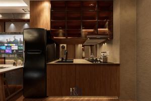 a kitchen with a black refrigerator and wooden cabinets at Premium Unit in Maldives in Manila +2 photos