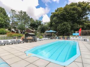 a large swimming pool with chairs and a table at Valley Lodge 61 in Callington