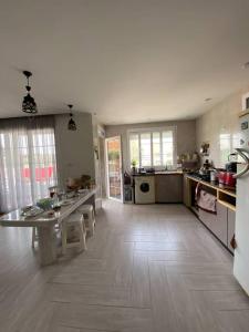 een grote keuken met een tafel en stoelen. bij Appartement Boulimat Bejaia in Matriouene