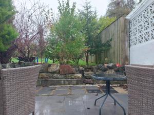 a patio with a table and two chairs and a fence at The Wee Nest in Largs - One-Bedroom Ground Flat in Largs