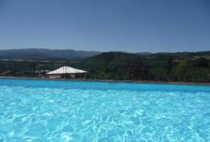 a large pool of blue water with a building in the background at Magnolia in Pratovecchio +13 photos
