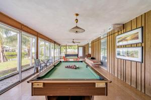 a pool table in a room with windows at Waterfront Home by Ralph Twitchell in Sarasota