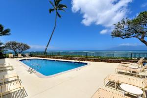 een zwembad met stoelen en uitzicht op de oceaan bij Kahana Reef 117 · KR 117 Renovated OceanFront 1BD w Ocean Views in Kahana