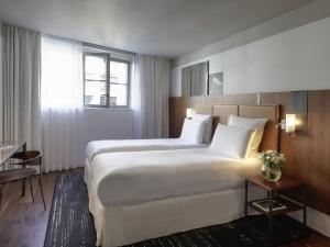 a hotel room with a large bed and a window at Boutet Bastille Hotel Paris - MGallery Collection in Paris