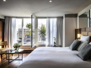 a bedroom with a large bed and a balcony at Boutet Bastille Hotel Paris - MGallery Collection in Paris
