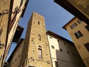 un edificio alto con una torre de reloj al lado de un edificio en Badia Fiorentina, en Florencia