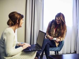 duas mulheres sentadas uma ao lado da outra com um laptop em Mercure Haydock Hotel em Haydock mais 49 fotografias
