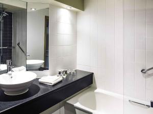 黑多克黑多克美居酒店 的一间白色浴室，配有洗手池和镜子。