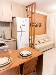 a kitchen with a table with chairs and a refrigerator at Refugio a 50 passos do mar in Tamandaré