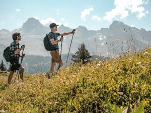 deux hommes marchant sur une montagne avec leurs sacs à dos dans l'établissement Studio montagnard chaleureux, animaux admis, parking, proche Grand-Bornand - FR-1-467-35, au Grand-Bornand 2 autres photos