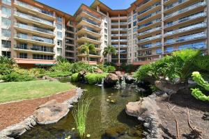 a hotel with a pond in front of a building at Honua Kai 322 · HK 322 Luxurious Kaanapali BeachFront 2BD Pool A in Lahaina