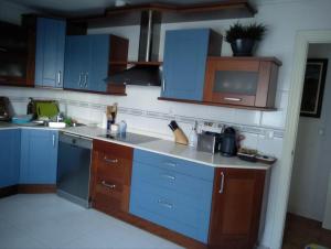 una cucina con armadi blu e piano di lavoro di Villa La Perla De Sonabia a Oriñón