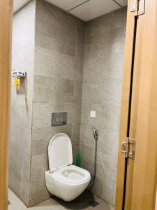 a bathroom with a white toilet in a stall at Sixty one stays in Greater Noida
