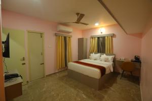 een slaapkamer met een bed, een bureau en een televisie bij AG Corporate Stay in Mahindra World City in Singapperumālkovil