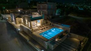 an overhead view of a house with a swimming pool at Ammos Luxury Villas Salamina in Aiándion