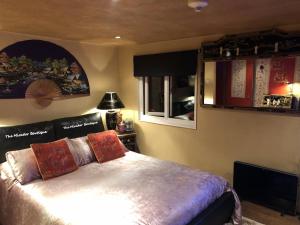 a bedroom with a bed and a tv in a room at Have tonights dreams wrapped in Chinese silk in Swansea