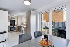 a kitchen and dining room with a table with a bottle of wine at Finest Retreats - Ffordd Y Meillion in Llanelli