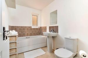 a white bathroom with a toilet and a sink at Finest Retreats - Ffordd Y Meillion in Llanelli +18 photos