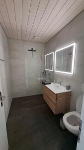 Un baño con lavabo e inodoro en Mountain view with balcony and free parking, en Lungern