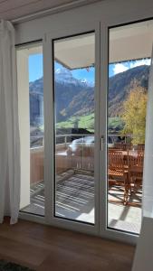 una puerta corredera de cristal con vistas a una mesa en Mountain view with balcony and free parking, en Lungern