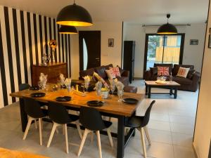 ein Esstisch und Stühle in einem Wohnzimmer in der Unterkunft L Atelier Veulais in Veules-les-Roses + 32 Fotos