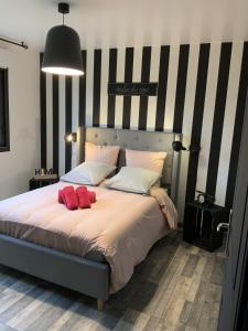 ein Schlafzimmer mit einem großen Bett mit zwei roten Kissen in der Unterkunft L Atelier Veulais in Veules-les-Roses