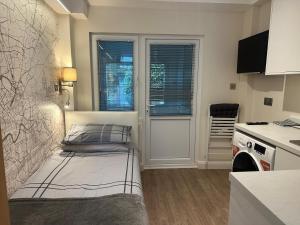 a small room with a bed in a kitchen at Unique space in Edgware in Stone Grove