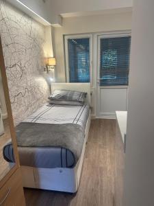 a bedroom with a bed and two windows at Unique space in Edgware in Stone Grove