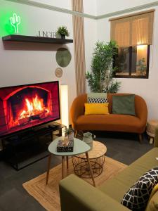 エペルネーにあるLes Loges Du Théatre 160m2 PRIVÉ 14 personnes MAX tout équipé a 200m de l'AVENUE DE CHAMPAGNE et toutes commodités DEGUSTATION CHAMPAGNE OFFERTE jacuzzi sauna jeux velos EMPLACEMENT EXCEPTIONNEL et CHICのソファと暖炉のあるリビングルーム