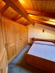 a bedroom with a bed and wooden ceilings at Pragma Apartments - Casa Defrancesco in Cavalese
