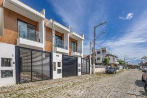 皮萨拉斯Casa c/ Churrasq. a 500 m da Praia CGE0003的街道边设有车库门的建筑