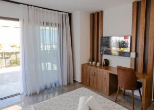 a living room with a desk and a large window at Suya Studios by HolidayKeys in Karavas