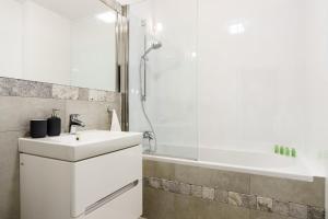 a white bathroom with a sink and a shower at Flatbook - City Center Comfort Studio in Gdańsk +24 photos