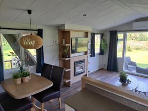 a caravan dining room and living room with a table and chairs at B&B Landlust in Ons Belang