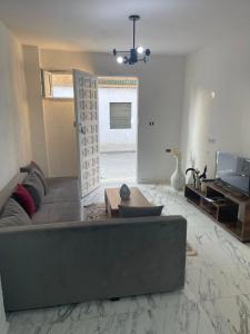 een woonkamer met een bank en een televisie bij Marsa home in Dar Tahar Zaouch