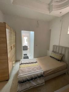 een slaapkamer met een groot bed en een kast bij Marsa home in Dar Tahar Zaouch