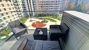 尼什Fluvius Suite - Riverside Elegance in the Heart of Niš with Free Parking的建筑物上的带桌椅的阳台