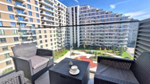 尼什Fluvius Suite - Riverside Elegance in the Heart of Niš with Free Parking的一个带桌椅的阳台和一座大型建筑