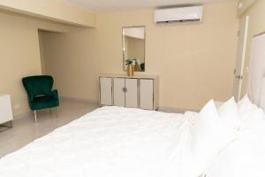 Un dormitorio con una cama, un espejo y una silla. en La Isla Royal - Abismo Celeste, en Miches 4 fotos más