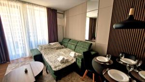 尼什Fluvius Suite - Riverside Elegance in the Heart of Niš with Free Parking的客厅里有一张绿色的沙发和一张桌子 更多17张照片