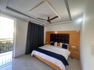 una camera da letto con un letto e un ventilatore a soffitto di A Hotel & Restaurant a Mussoorie