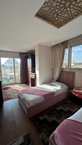 a bedroom with two beds and a large window at Golden Pyramids View Inn in Cairo
