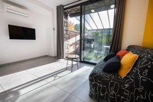 a living room with a couch and a tv at N10 Maison T2 climatisé avec jacuzzi privé in Ajaccio