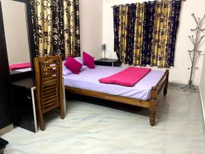 a bedroom with a bed with pink pillows at Cardamom valley Home stay in Vagamon +3 photos