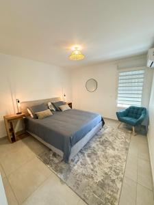 une chambre avec un grand lit et une chaise bleue dans l'établissement Appartement Madinina View, à Fort-de-France