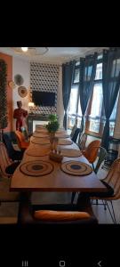 エペルネーにあるLes Loges Du Théatre 160m2 PRIVÉ 14 personnes MAX tout équipé a 200m de l'AVENUE DE CHAMPAGNE et toutes commodités DEGUSTATION CHAMPAGNE OFFERTE jacuzzi sauna jeux velos EMPLACEMENT EXCEPTIONNEL et CHICの部屋にある長い木のテーブルと椅子