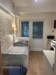 a bedroom with a bed and two windows at Unique space in Edgware in Stone Grove
